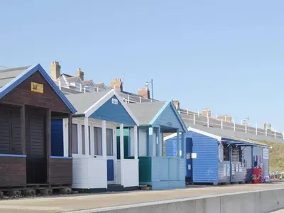a row of colourful beach houses on a street at The Cart Shed - E1768 in Westleton