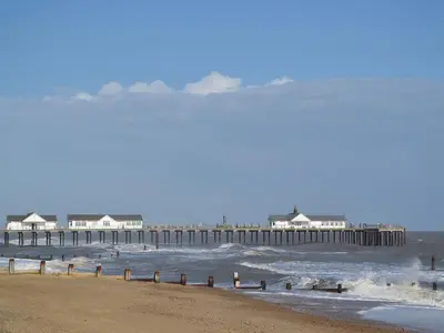 a view of a beach with a pier in the water at The Cart Shed - E1768 in Westleton