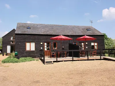 a house with tables and umbrellas in front of it at Heron in Welney