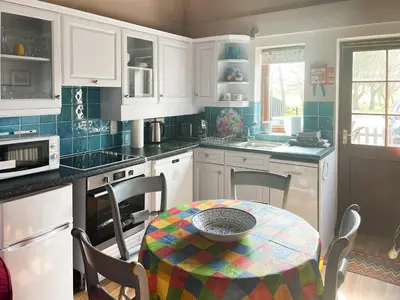 a kitchen with white cabinets and a table with a bowl on it at Heron in Welney