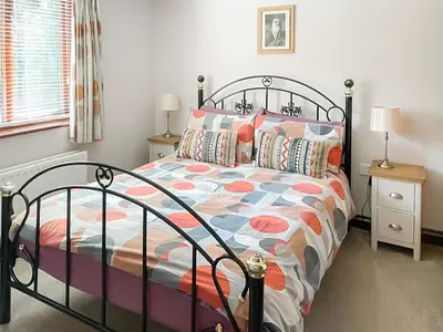 a bedroom with a bed with a colorful comforter at Heron in Welney