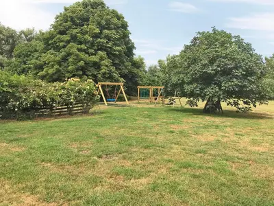 a park with a swing set and a tree at Heron in Welney