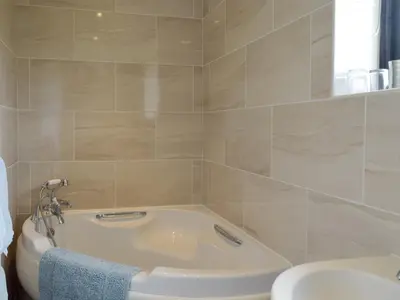a bathroom with a bath tub and a toilet at Carol's Cottage - E3043 in Blyford