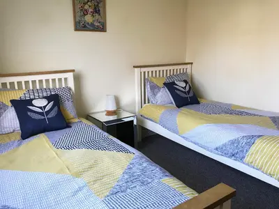 a room with two beds and a lamp on a table at Kestral in Welney