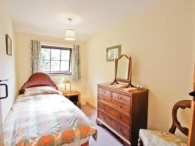 a bedroom with a bed and a dresser and a window at The Stables - E3491 in Saxtead