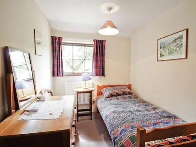 a small bedroom with a bed and a desk at The Stables - E3491 in Saxtead