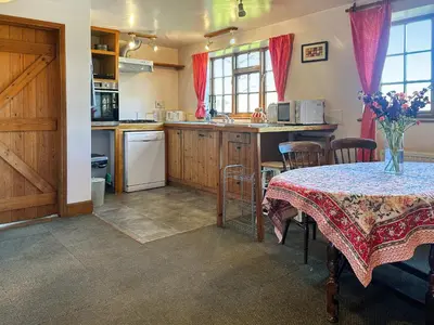 a kitchen with a table with a table cloth on it at Field Cottage in Sudbourne