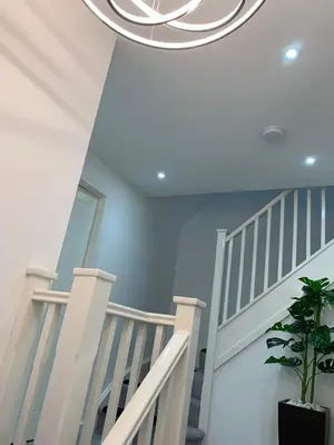 a white staircase with a potted plant at BYK Homes, Hotels and Suites in Grays Thurrock