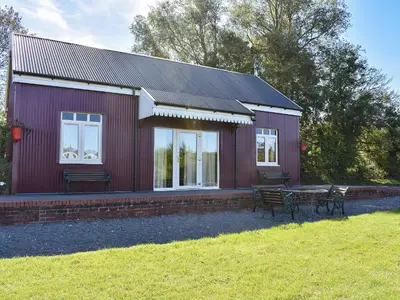 a red house with a picnic table in front of it at The Station - E5336 in Wetheringsett