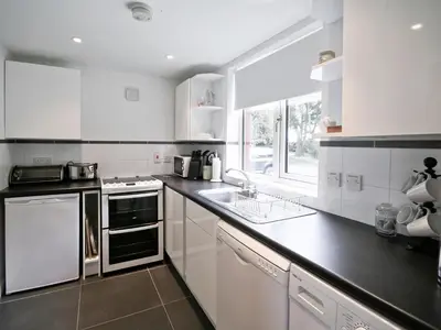 a white kitchen with white appliances and a window at The Station - E5336 in Wetheringsett