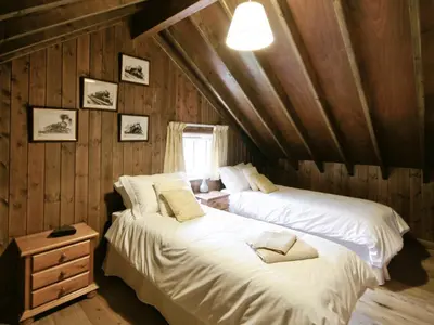 two beds in a room with wood paneling at The Station - E5336 in Wetheringsett
