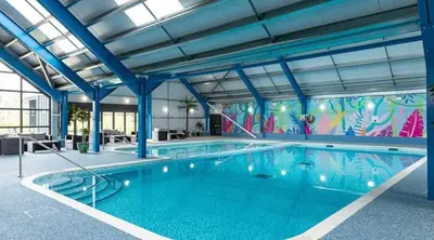 a large swimming pool in a building at Marie Helene, 58 Mallard Carlton Meres Holiday Park in Kelsale