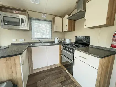 a kitchen with white cabinets and a stove top oven at Marie Helene, 58 Mallard Carlton Meres Holiday Park in Kelsale