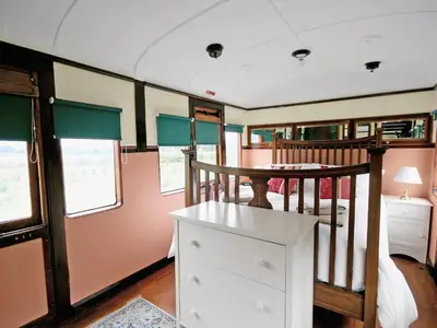 a train room with a bed and a table at Railway Carriage Two - E5601 in Wetheringsett