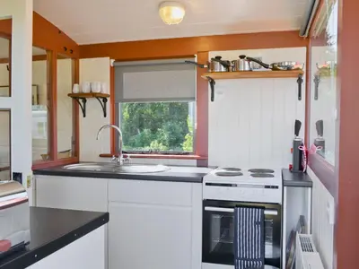 a small kitchen with a sink and a stove at The Guards Van in Wetheringsett