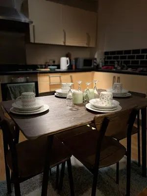 a wooden table with plates and dishes on it in a kitchen at Serenity-ESE Entire Home in Basildon