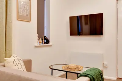 a living room with a couch and a table at Stylish and modern studio flat Free parking - Pass the Keys in Cambridge