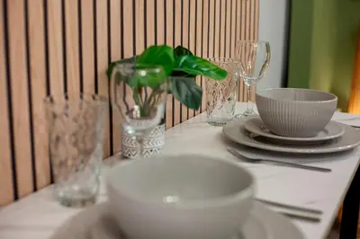 a table with a white bowl and plates and glasses at Stylish and modern studio flat Free parking - Pass the Keys in Cambridge