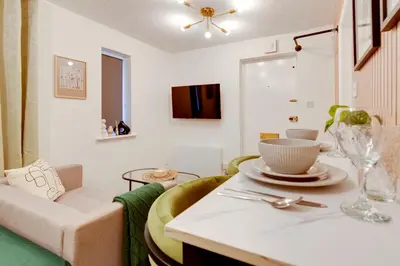 a living room with a table and a couch at Stylish and modern studio flat Free parking - Pass the Keys in Cambridge