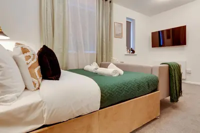 a bedroom with a bed with a couch and a window at Stylish and modern studio flat Free parking - Pass the Keys in Cambridge
