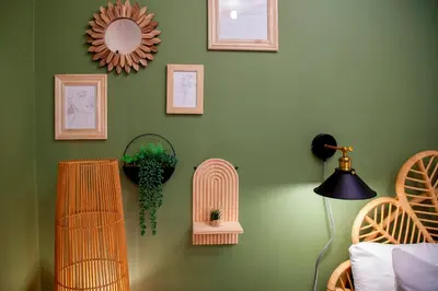 a room with green walls with wicker baskets and a lamp at Stylish and modern studio flat Free parking - Pass the Keys in Cambridge