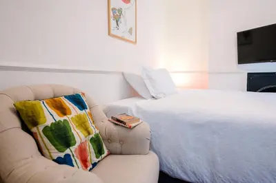 a bedroom with a bed and a chair with a pillow at Lower Cedars, Saxmundham in Saxmundham