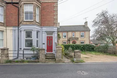 a house with a red door on a street at Lower Cedars, Saxmundham in Saxmundham