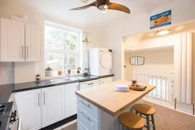 a kitchen with white cabinets and a counter top at Lower Cedars, Saxmundham in Saxmundham