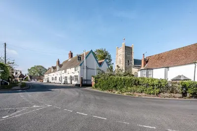 an empty street in a small town with houses at Buoys Cottage, Orford in Orford