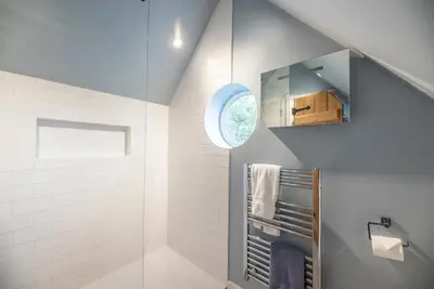 a bathroom with a walk in shower and a window at Buoys Cottage, Orford in Orford
