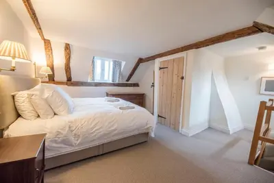 a bedroom with a bed and a desk and a window at Buoys Cottage, Orford in Orford