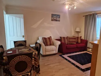 a living room with two chairs and a red couch at Comfortable holiday home in Basildon Essex in Laindon