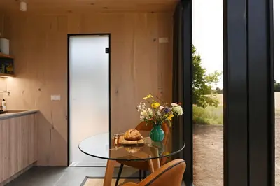a glass table in a kitchen with a glass door at Mirror Houses Pound Farm - Pond OOD in Saxmundham