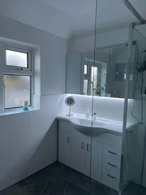 a white bathroom with a sink and a mirror at House in city centre with free parking in Cambridge