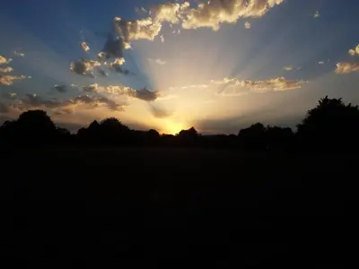 a sunset in a field with the sun in the sky at House in city centre with free parking in Cambridge