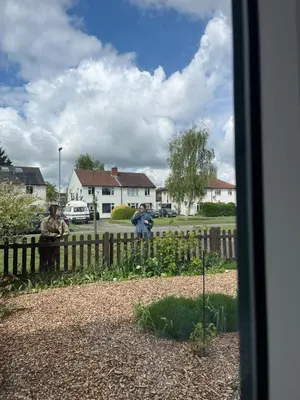 a couple of people standing next to a fence at House in city centre with free parking in Cambridge