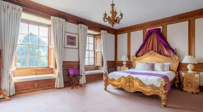 a bedroom with a bed with a purple canopy at Hockwold Hall - Former Royal residence in Hockwold cum Wilton