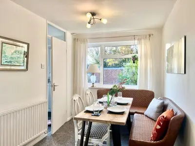 a living room with a table and chairs and a window at Bright, artsy 3BR home with parking & long term stay in Saffron Walden