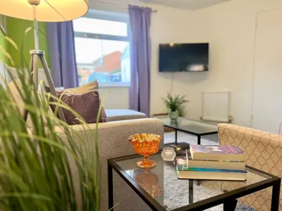 a living room with a couch and a table at Bright, artsy 3BR home with parking & long term stay in Saffron Walden