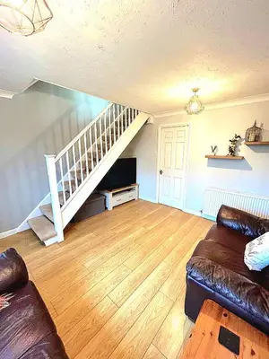 a living room with a couch and a staircase at 2 Bedroom House off A12 Colchester in Lexden
