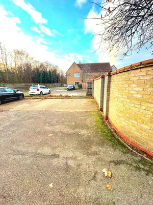a car parked in a parking lot next to a brick wall at 2 Bedroom House off A12 Colchester in Lexden