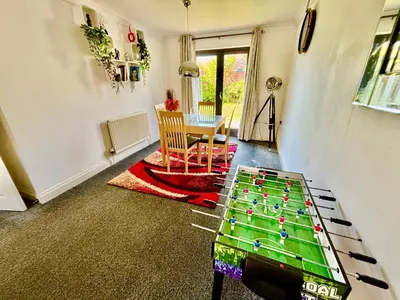 a living room with a table in the middle of a room at Conveniently located 3 bed spacious home for couples, families and groups in Ipswich in Ipswich