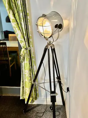 a lamp on a tripod next to a curtain at Conveniently located 3 bed spacious home for couples, families and groups in Ipswich in Ipswich