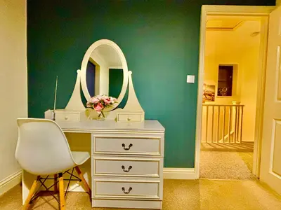 a dressing table with a mirror and a chair at Conveniently located 3 bed spacious home for couples, families and groups in Ipswich in Ipswich