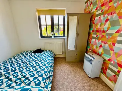 a small bedroom with a bed and a window at Conveniently located 3 bed spacious home for couples, families and groups in Ipswich in Ipswich