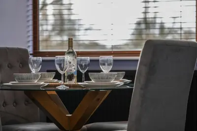 a table with glasses and a bottle of wine on it at Oak View Lodge Luxury Master Studio near Ipswich & Woodbridge in Playford