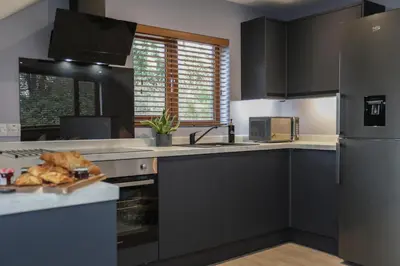 a kitchen with black cabinets and a plate of bread at Oak View Lodge Luxury Master Studio near Ipswich & Woodbridge in Playford