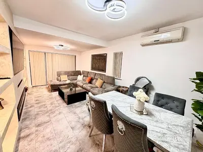 a living room with a table and a couch at Double bedrooms In Spacious Home in Harold Wood