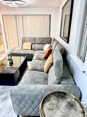 a living room with a couch and a table at Double bedrooms In Spacious Home in Harold Wood