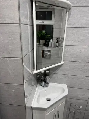 a bathroom with a sink and a mirror at Double bedrooms In Spacious Home in Harold Wood